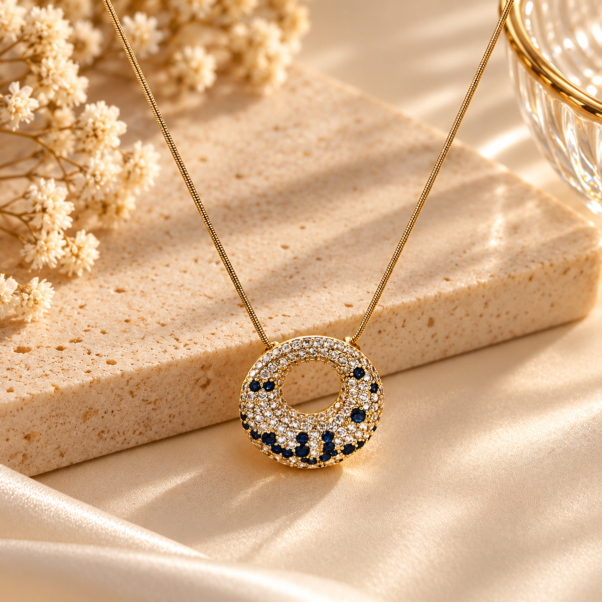 Pendentif rond doré ajouré avec détails bleus et clairs scintillants